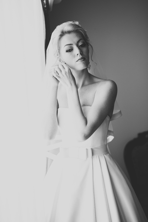 Luxury bride in white dress posing while preparing for the wedding ceremonyの写真素材