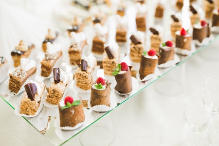 Delicious and tasty dessert table with cupcakes shots at reception closeupの写真素材