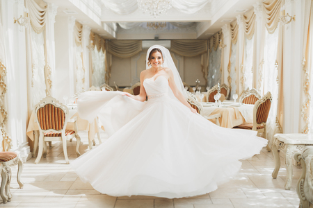 Beautiful bride posing in wedding dress in fashion hotelの写真素材