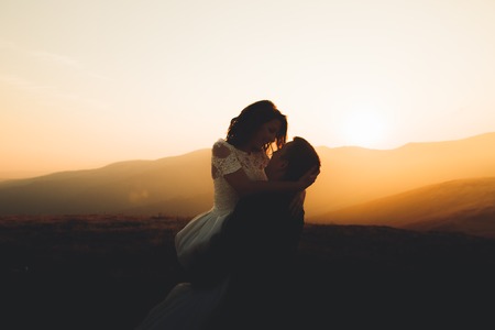 Wedding couple posing on sunset at wedding day. Bride and groom in loveの写真素材