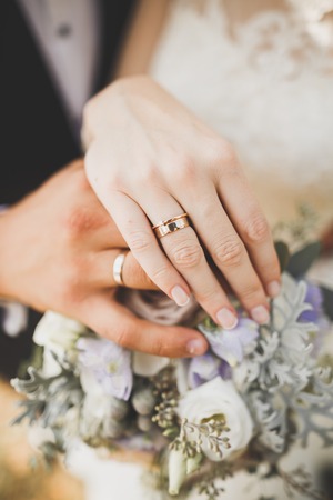 Newly wed couples hands with wedding ringsの写真素材