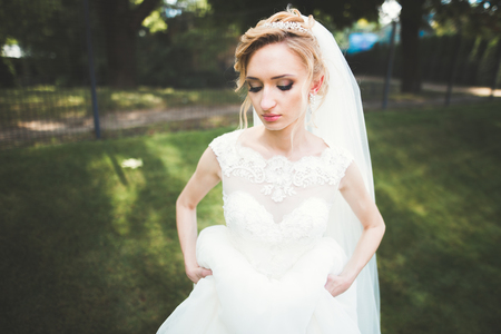 Beautiful bride posing in wedding dress outdoorsの写真素材