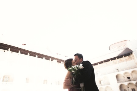 Happy wedding couple, groom, bride with pink dress hugging and smiling each otherの写真素材