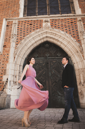 Gorgeous wedding couple, groom and bride with pink dress walking in the old city of Krakowの写真素材