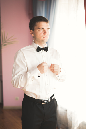 Beautiful man, groom posing and preparing for weddingの写真素材