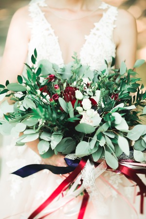 Bride holding big and beautiful wedding bouquet with flowersの写真素材