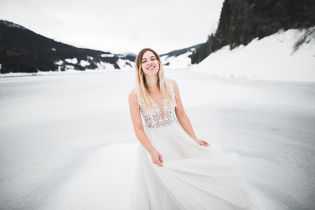 Beautiful bride with a bouquet on mountain backgroundの写真素材
