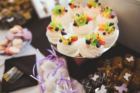 Delicious and tasty dessert table with cupcakes and shots at reception closeup.の写真素材