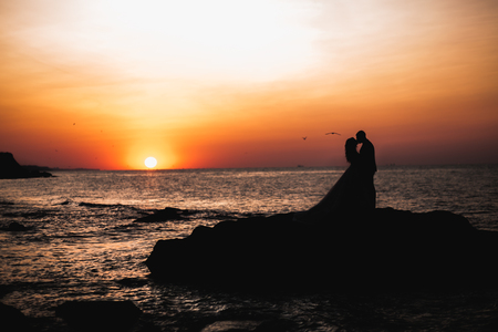 Happy and romantic scene of just married young wedding couple posing on beautiful beach.の写真素材