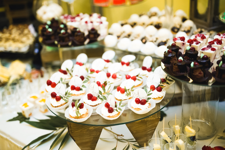 Delicious sweets on wedding candy buffet with desserts, cupcakesの写真素材