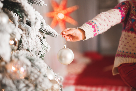 Happy girl decorating a beautiful Christmas tree.の写真素材