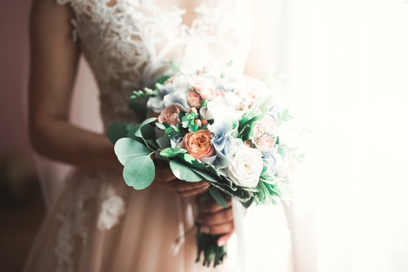 Bride holding big and beautiful wedding bouquet with flowersの写真素材