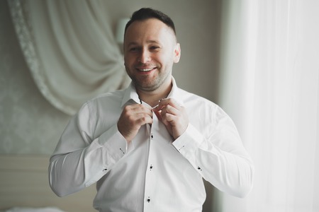Young handsome man relaxing at his apartment in a hotel after business meetingの写真素材