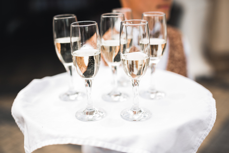 Waiter serving glasses with champagne on a trayの写真素材