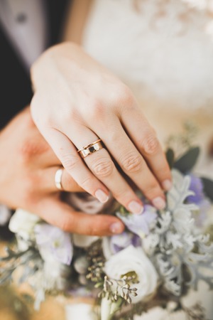 Newly wed couple's hands with wedding rings.の写真素材
