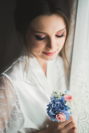 Beautiful bride wearing fashion wedding dress with feathers with luxury delight make-up and...