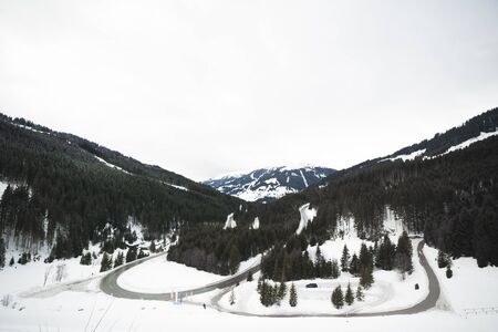 Beautiful winter wonderland scenery with trees and mountain tops in the Alps.