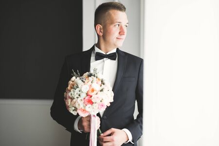 Grooms morning preparation. Handsome man getting dressed and preparing for the weddingの写真素材