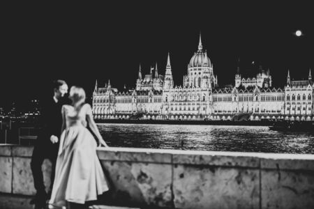 Stylish beautiful wedding couple kissing and hugging on background panoramic view of the old townの写真素材