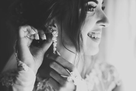 Beautiful bride wearing fashion wedding dress with feathers with luxury delight make-up and hairstyle, studio indoor photo shootの写真素材