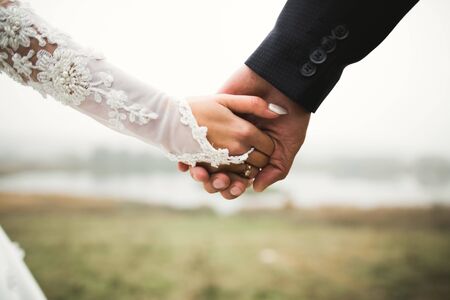 Wedding couple holding hands, groom and bride together on wedding dayの写真素材