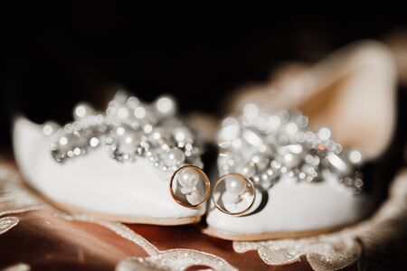 Beautiful toned picture with wedding rings and wedding shoesの写真素材