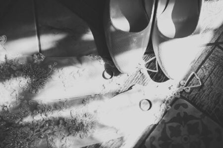 Beautiful toned picture with wedding rings and wedding shoes.の写真素材