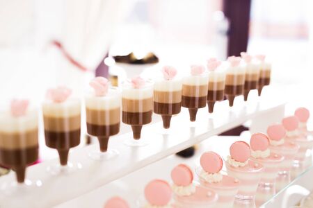 Delicious sweets on wedding candy buffet with desserts, cupcakes.の写真素材