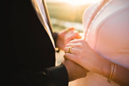 Wedding couple holding hands, groom and bride together on wedding dayの写真素材