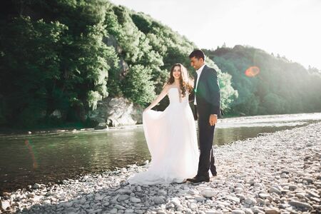Sunshine portrait of happy bride and groom outdoor in nature locationの写真素材