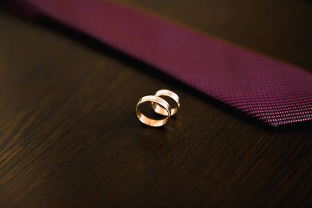 Two golden wedding rings on a tie isolated background concept.の写真素材