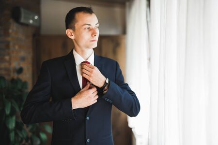 Young handsome man relaxing at his apartment in a hotel after business meetingの写真素材