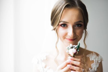 Beautiful bride wearing fashion wedding dress with feathers with luxury delight make-up and hairstyle, studio indoor photo shootの写真素材
