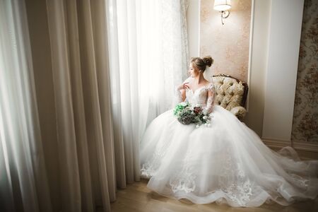 Luxury bride in white dress posing while preparing for the wedding ceremonyの写真素材