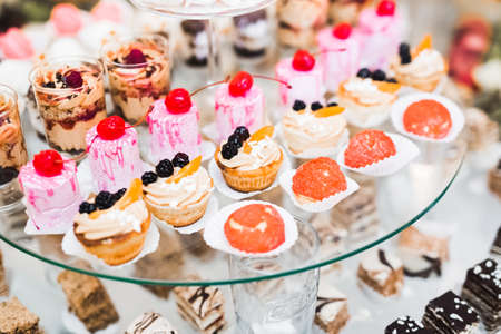 Delicious and tasty dessert table with cupcakes shots at reception closeupの写真素材