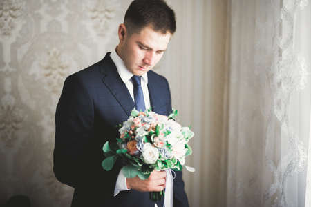 Young handsome man relaxing at his apartment in a hotel after business meetingの写真素材