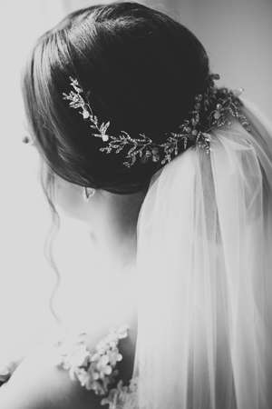 Gorgeous bride in robe posing and preparing for the wedding ceremony face in a roomの写真素材