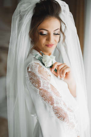 Beautiful luxury bride in elegant white dress holds bouquet of flowers in the handsの写真素材
