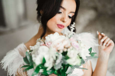 Beauty portrait of bride wearing fashion wedding dress with feathers with luxury delight make-up and hairstyleの写真素材