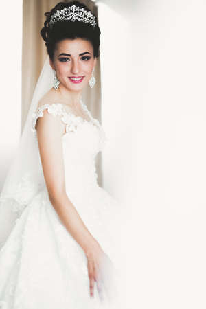 Luxury bride in white dress posing while preparing for the wedding ceremonyの写真素材