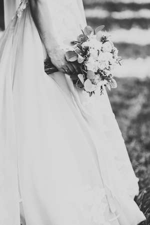 Beautiful luxury young bride in wedding dress posing in parkの写真素材