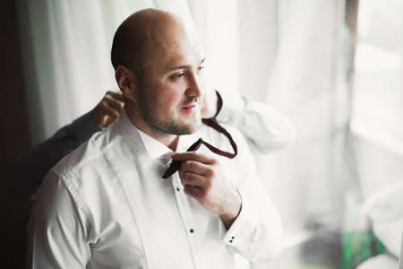 Beautiful man, groom posing and preparing for weddingの写真素材