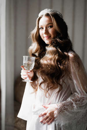 Beautiful bride wearing fashion wedding dress with feathers with luxury delight make-up and hairstyle, studio indoor photo shootの写真素材