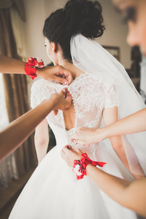 Gorgeous bride in robe posing and preparing for the wedding ceremony face in a roomの写真素材