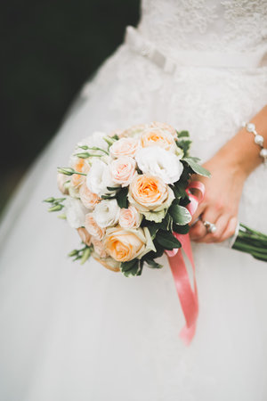 Bride holding big and beautiful wedding bouquet with flowersの写真素材