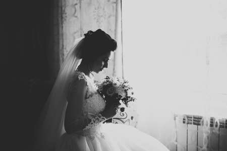 Luxury bride in white dress posing while preparing for the wedding ceremonyの写真素材