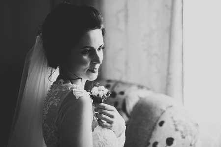 Beautiful bride wearing fashion wedding dress with feathers with luxury delight make-up and hairstyle, studio indoor photo shootの写真素材