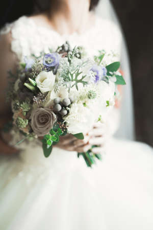 Bride holding big and beautiful wedding bouquet with flowersの写真素材