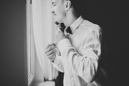 Grooms morning preparation. Handsome man getting dressed and preparing for the weddingの写真素材