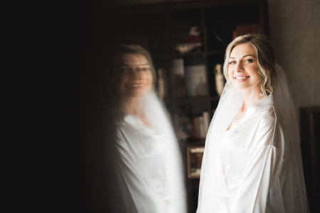 Beautiful bride wearing fashion wedding dress with feathers with luxury delight make-up and hairstyle, studio indoor photo shootの写真素材